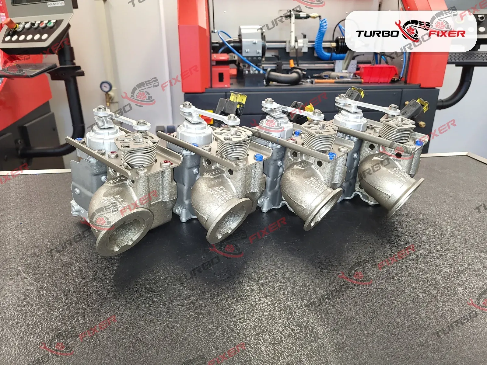 A row of four regenerated DAF BPV exhaust back-pressure valves on the test bench at our Poland workshop, calibration rig behind them.